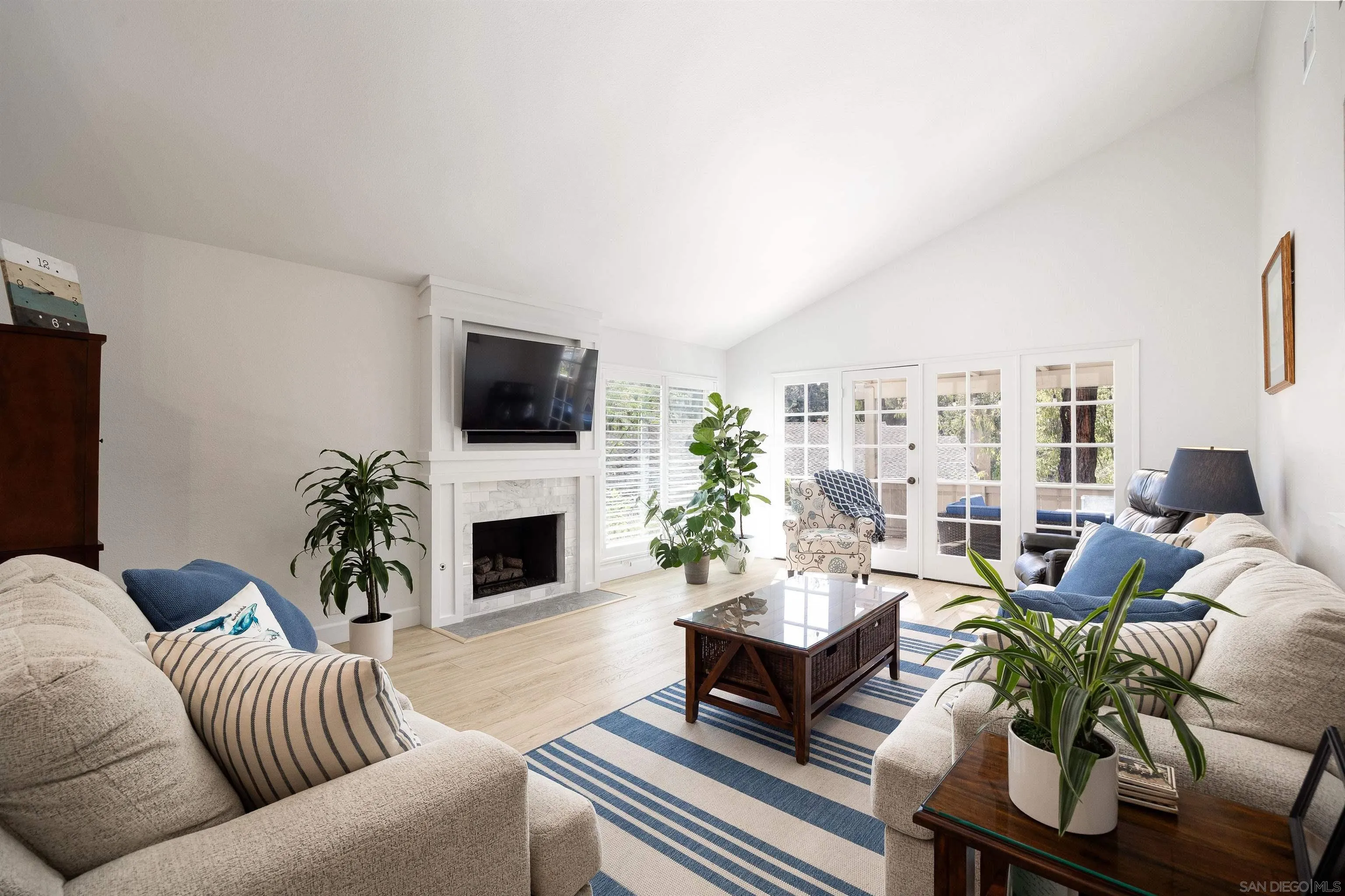 5611 Adobe Falls Road, Unit A San Diego, CA 92120 - Photo 6 of 30 a living room with furniture a fireplace and a flat screen tv