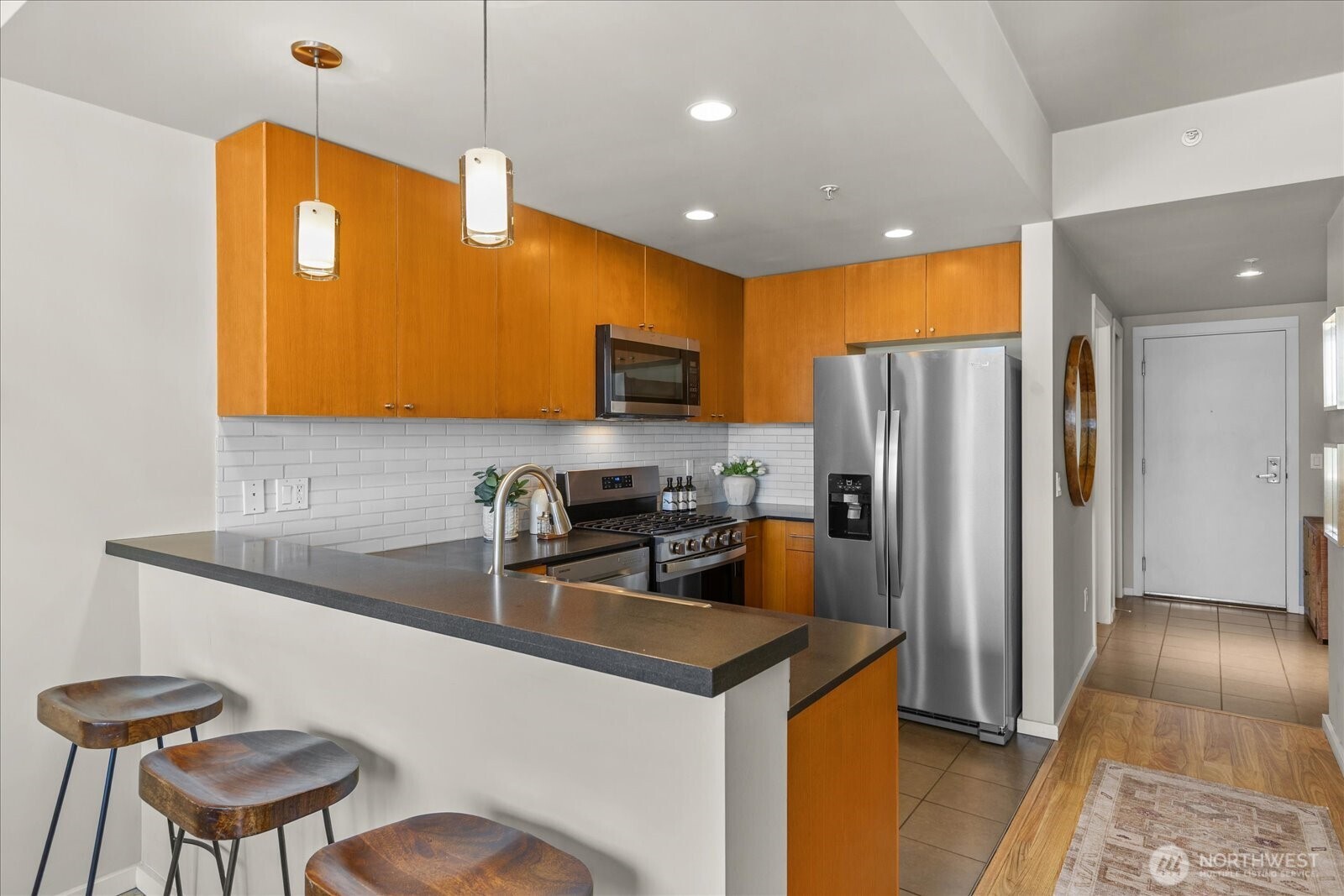 76 Cedar Street, Unit PH07 Seattle, WA 98121 - Photo 11 of 33 a kitchen with stainless steel appliances granite countertop a sink a stove a refrigerator a washer dryer and a dining table