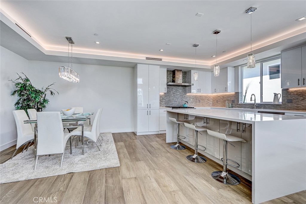 2701 Ruhland Avenue Redondo Beach, CA 90278 - Photo 14 of 38 a kitchen with stainless steel appliances granite countertop a table chairs stove a sink and dishwasher