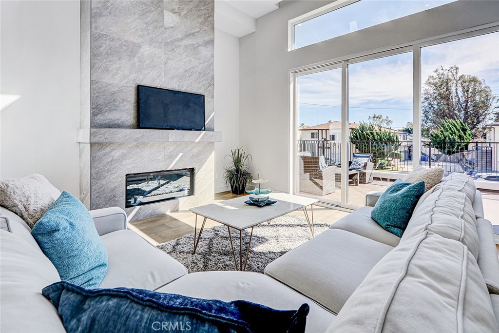 2701 Ruhland Avenue Redondo Beach, CA 90278 - Photo 17 of 38 a living room with furniture a fireplace and a floor to ceiling window