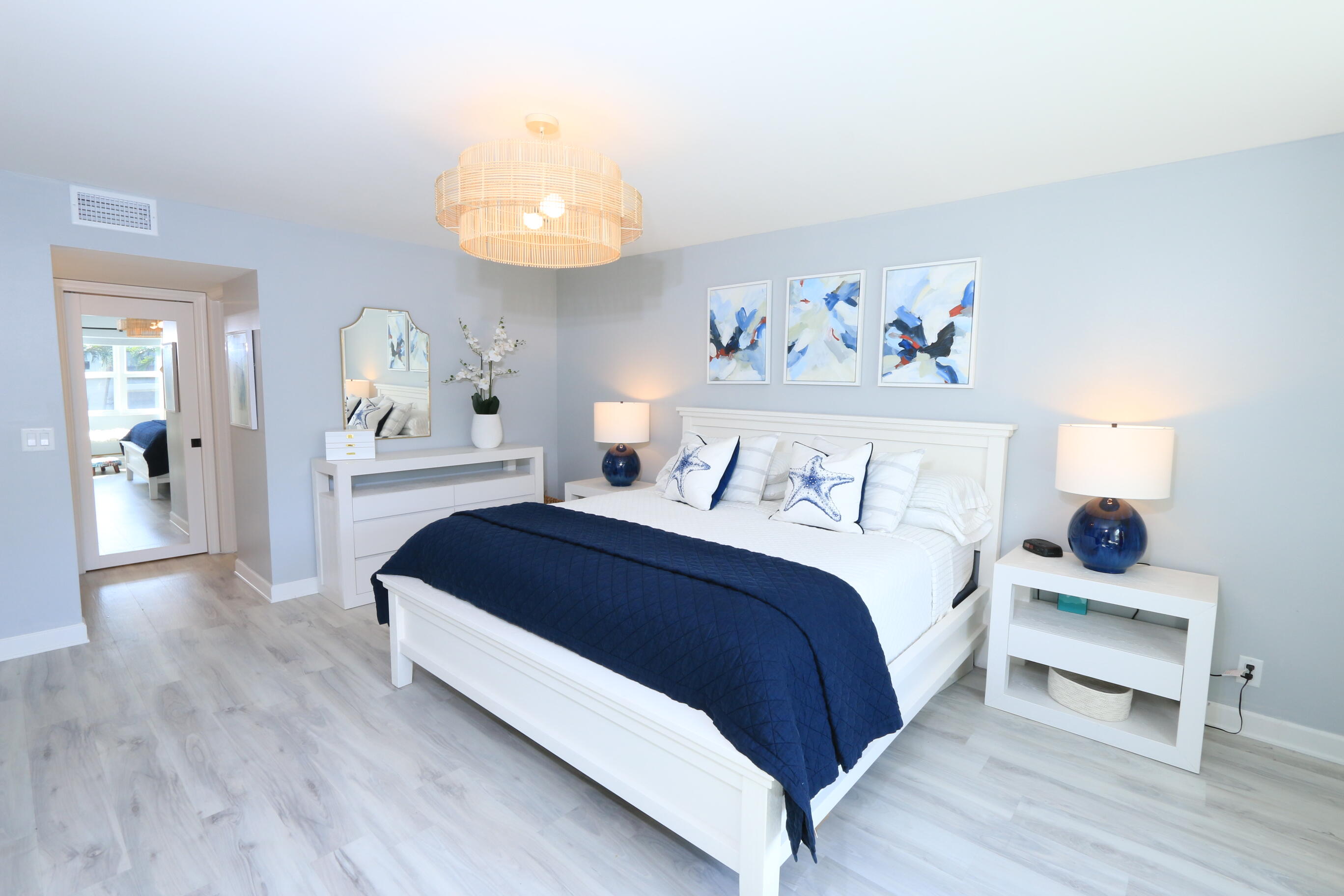 4161 U.S. Highway 1, Unit E3 Jupiter, FL 33477 - Photo 35 of 86 a spacious bedroom with a bed and a chandelier