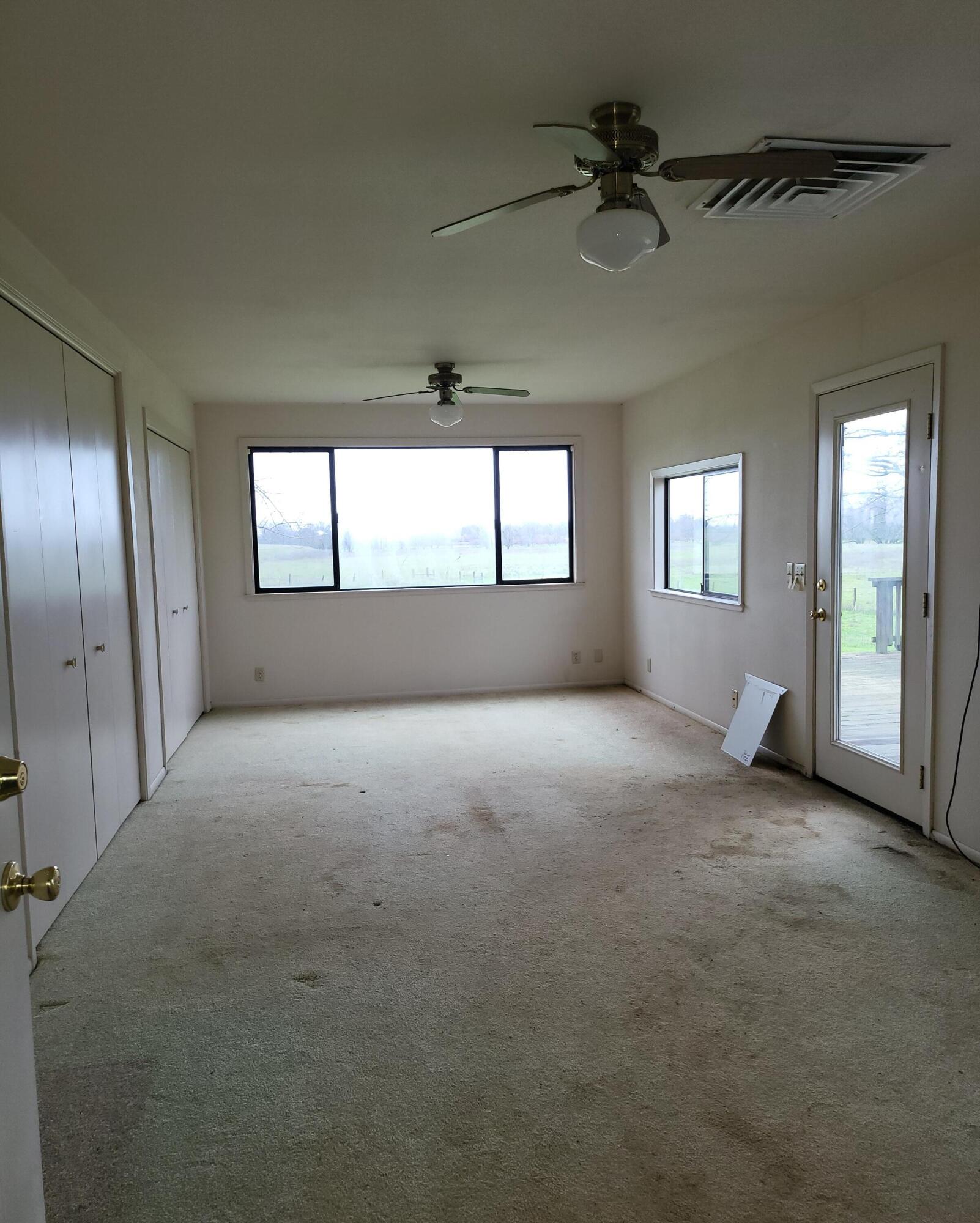 19009 Paskenta Road Corning, CA 96021 - Photo 21 of 33 an empty room with chandelier fan and windows