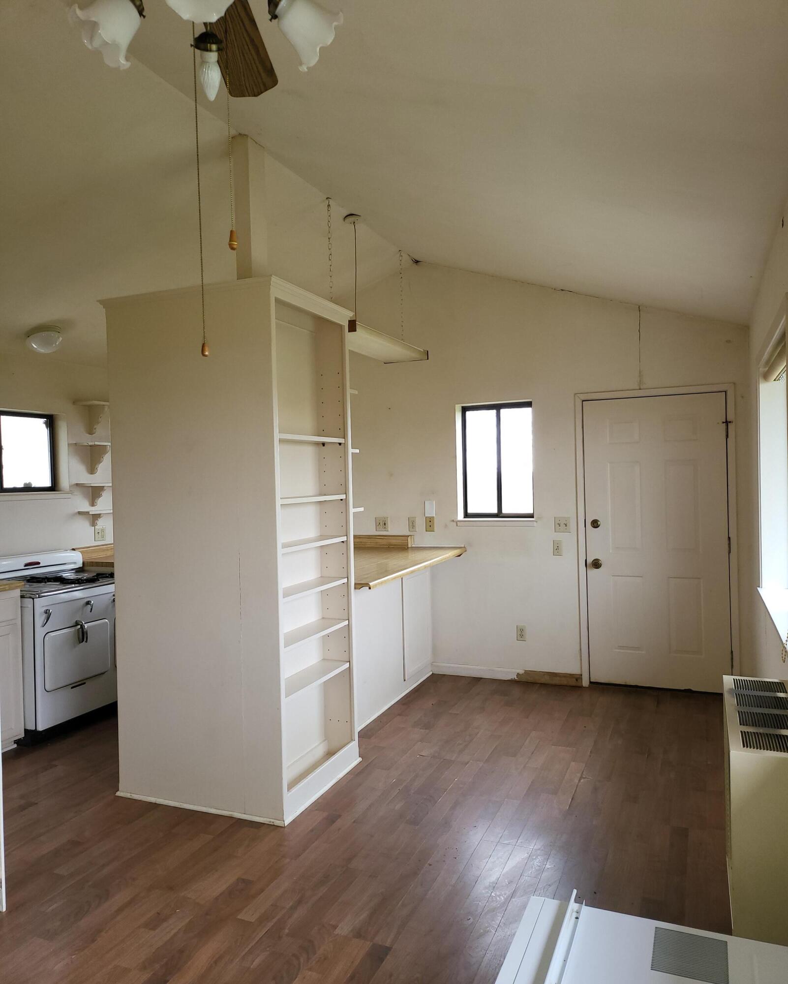 19009 Paskenta Road Corning, CA 96021 - Photo 10 of 33 an empty room with wooden floor cabinet and windows