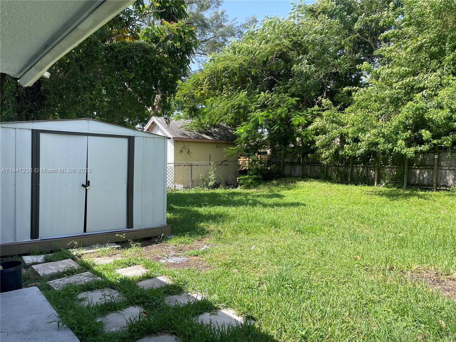 20048 Southwest 87th Place Cutler Bay, FL 33189 - Photo 11 of 11 a backyard of a house with plants and large tree