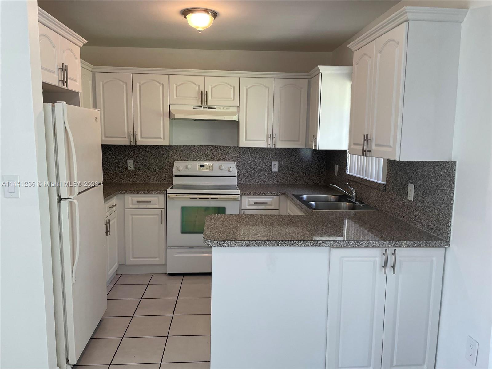 20048 Southwest 87th Place Cutler Bay, FL 33189 - Photo 5 of 11 a kitchen with stainless steel appliances granite countertop a refrigerator sink and stove