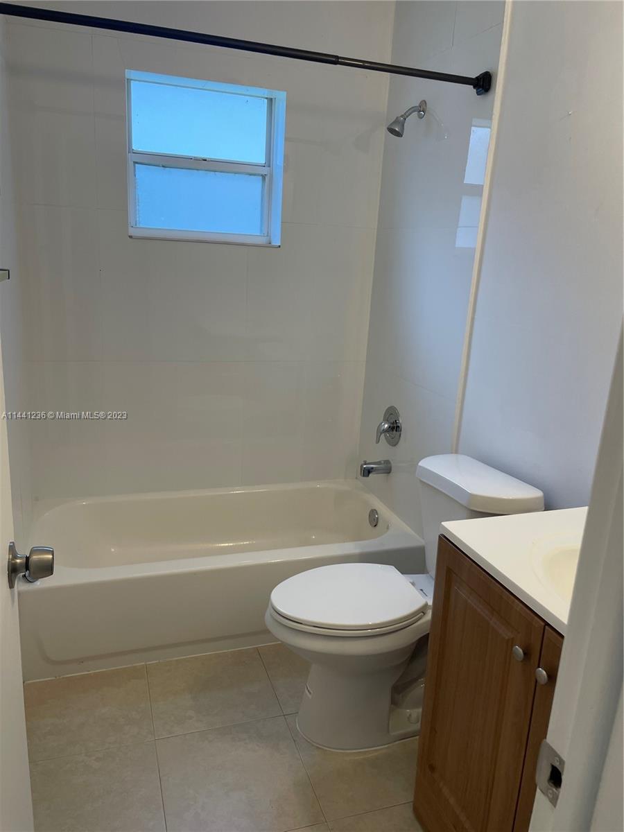 20048 Southwest 87th Place Cutler Bay, FL 33189 - Photo 9 of 11 a white toilet sitting next to a bath tub