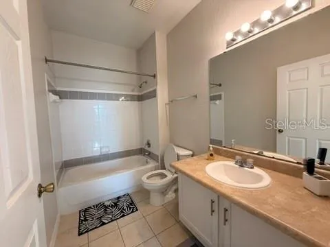 a bathroom with a granite countertop sink a toilet a mirror and shower