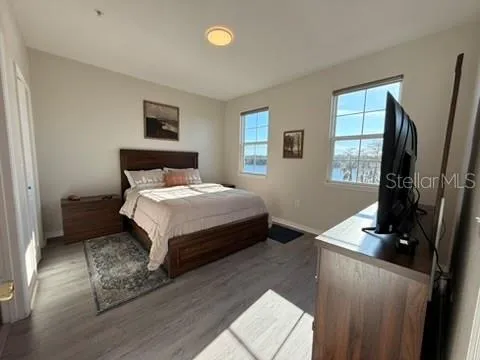 a bedroom with a bed window and a flat screen tv