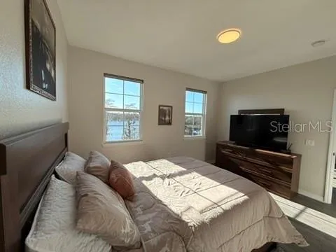 a bedroom with a bed and a flat screen tv