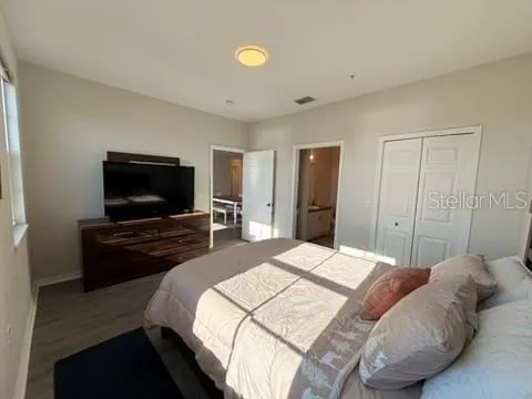 a bedroom with a bed and a flat screen tv