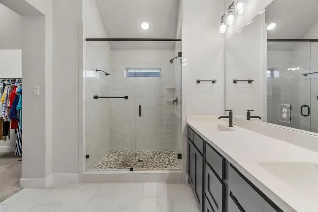 a bathroom with a shower sink and mirror