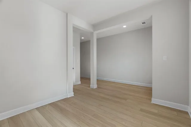 a view of an empty room with wooden floor