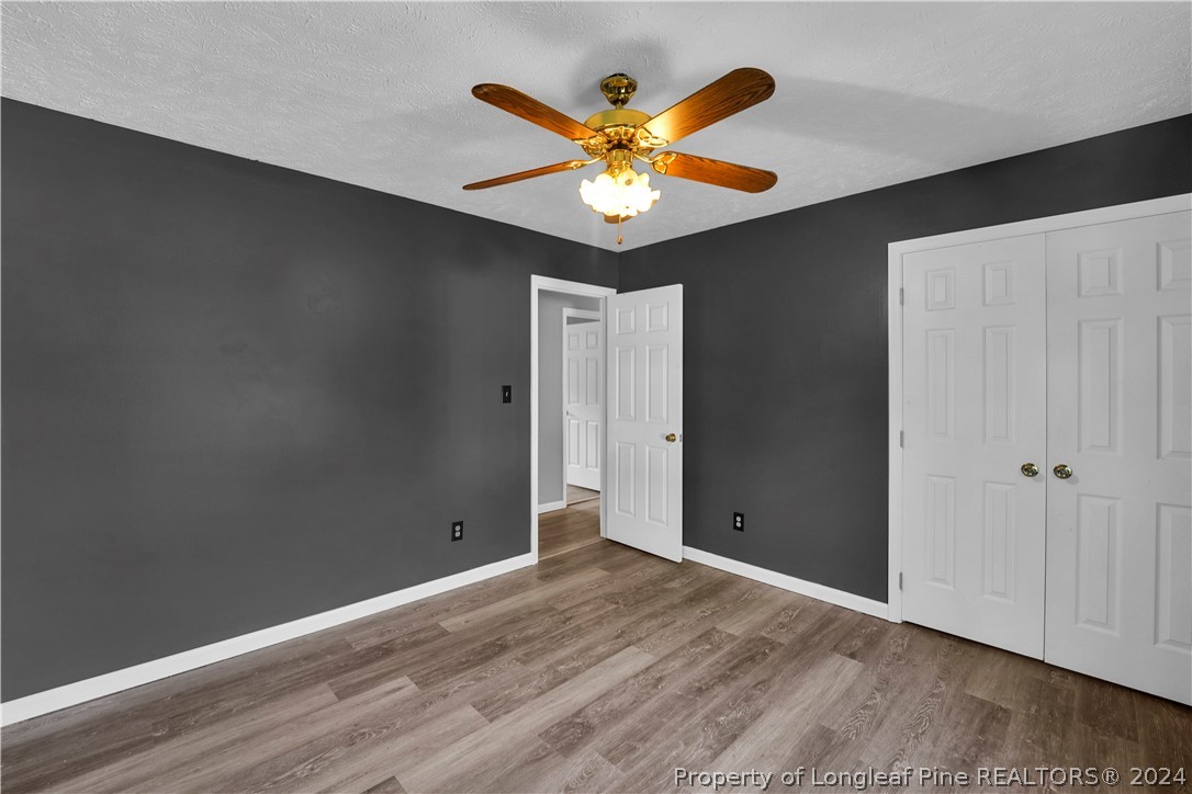 229 Lakeside Road Raeford, NC 28376 - Photo 14 of 17 a view of an empty room with wooden floor and a ceiling fan