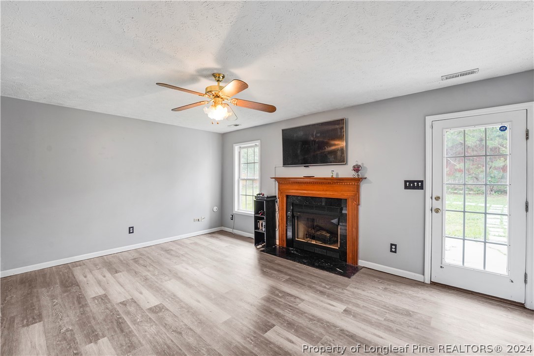 229 Lakeside Road Raeford, NC 28376 - Photo 5 of 17 a view of an empty room with a fireplace and a window