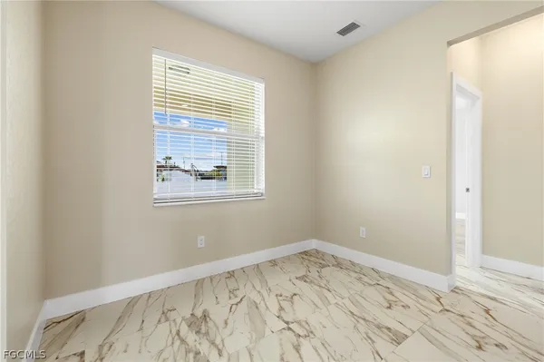 a view of a room with wooden floor and a window