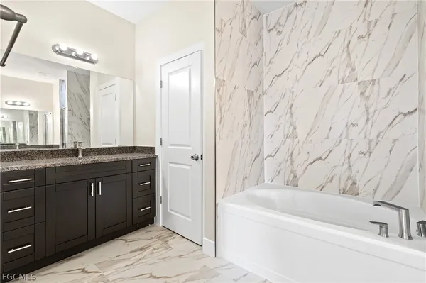 a bathroom with a tub sink and mirror