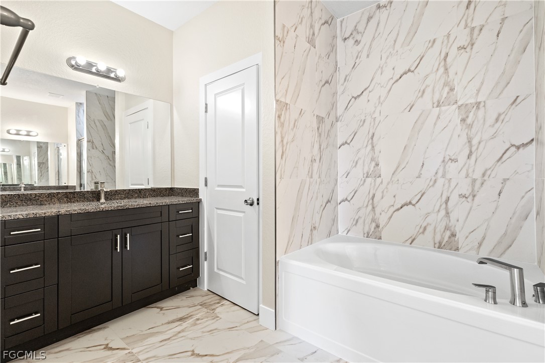 2919 23rd Street Southwest Lehigh Acres, FL 33976 - Photo 9 of 17 a bathroom with a tub sink and mirror