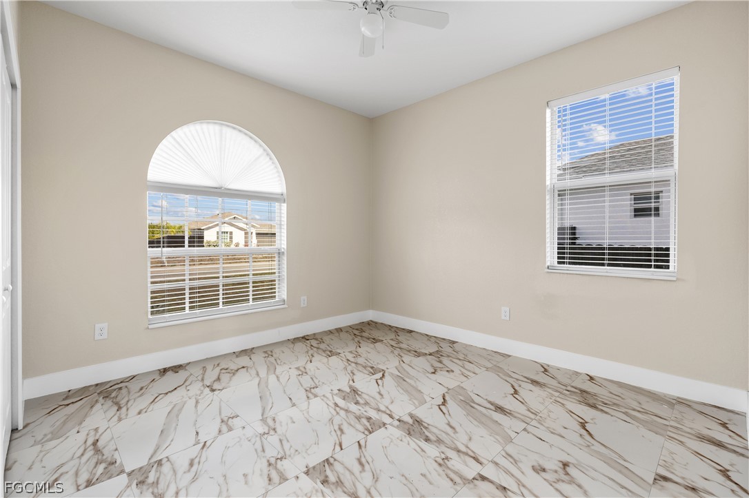 2919 23rd Street Southwest Lehigh Acres, FL 33976 - Photo 10 of 17 an empty room with wooden floor cabinet and windows