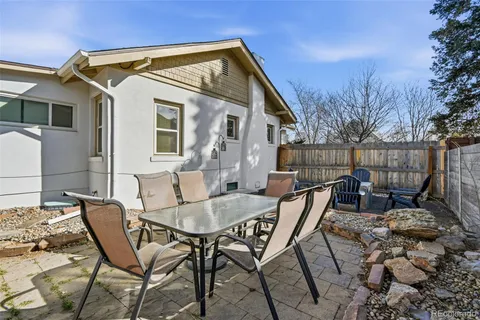a view of a patio with table and chairs with barbeque grill and plants