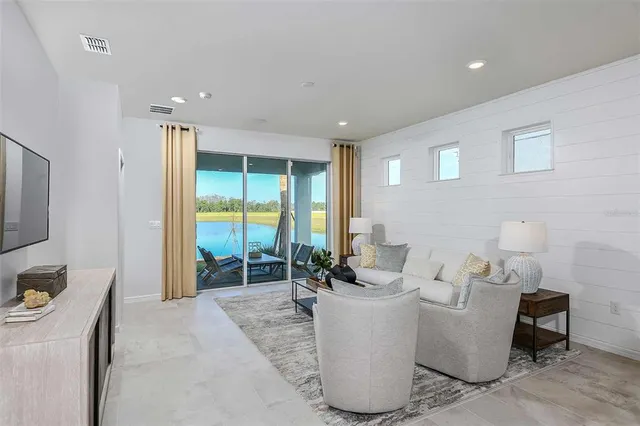 a living room with furniture a window and a flat screen tv