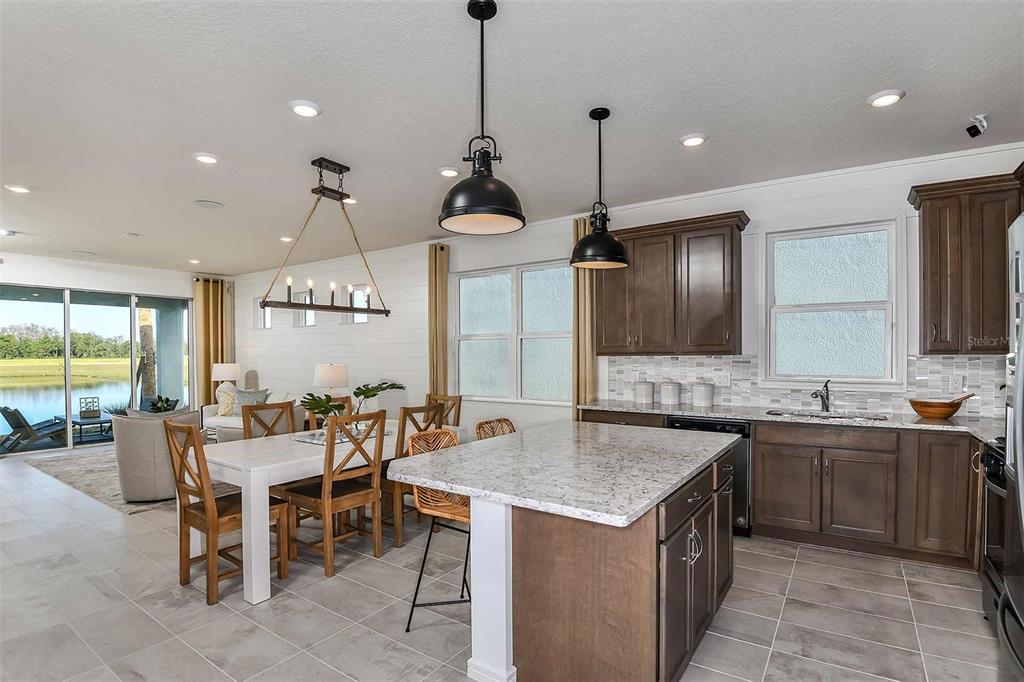 6318 Dew Drop Loop St. Cloud, FL 34771 - Photo 7 of 31 a kitchen with a stove a sink a counter top space and a center island