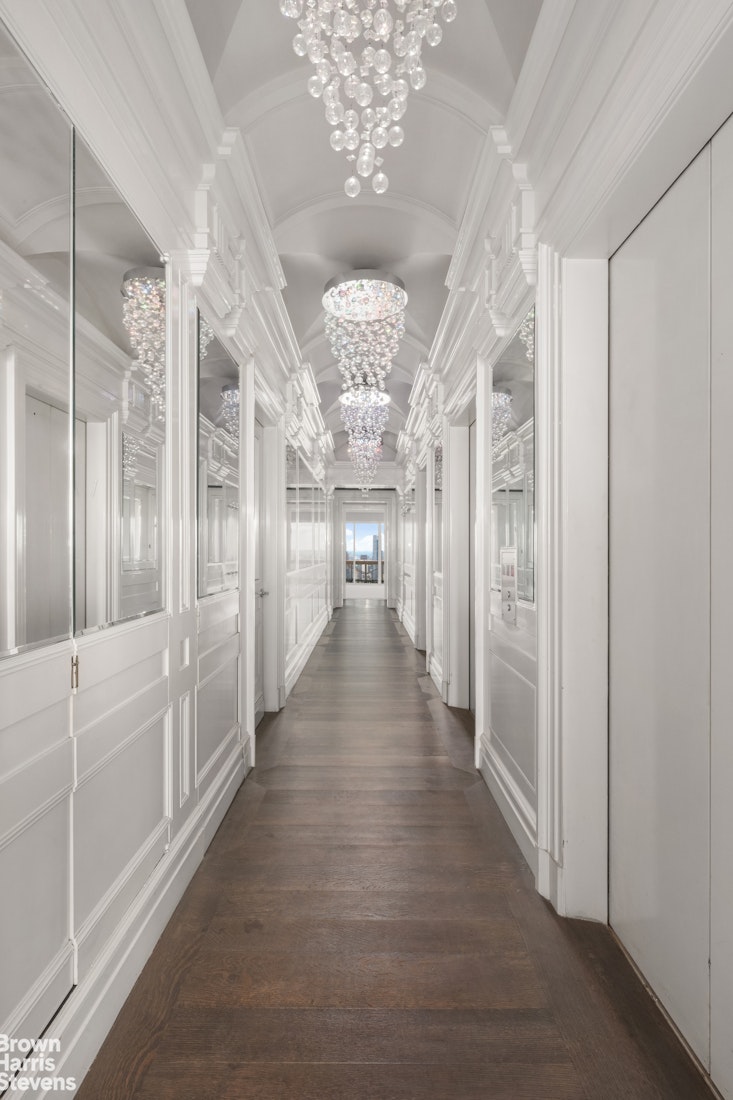 200 East 69th Street, Unit 47 Manhattan, NY 10021 - Photo 10 of 30 a view of a hallway with wooden floor and chandelier