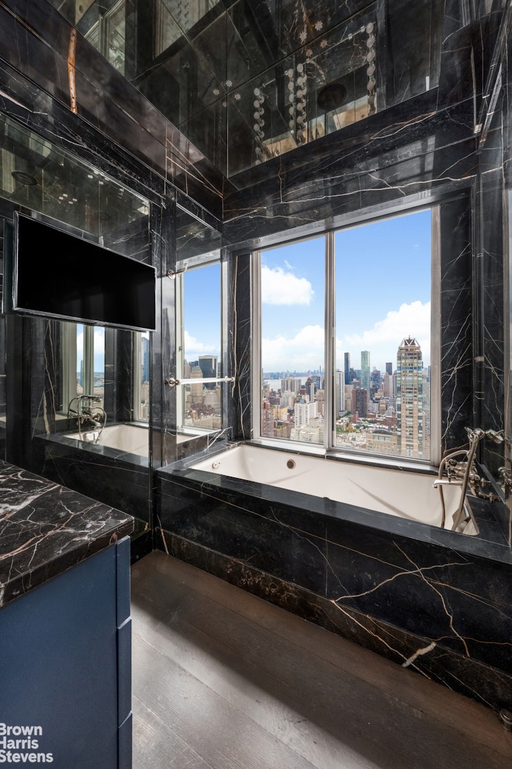 200 East 69th Street, Unit 47 Manhattan, NY 10021 - Photo 14 of 30 a bathroom with a large window and a sink