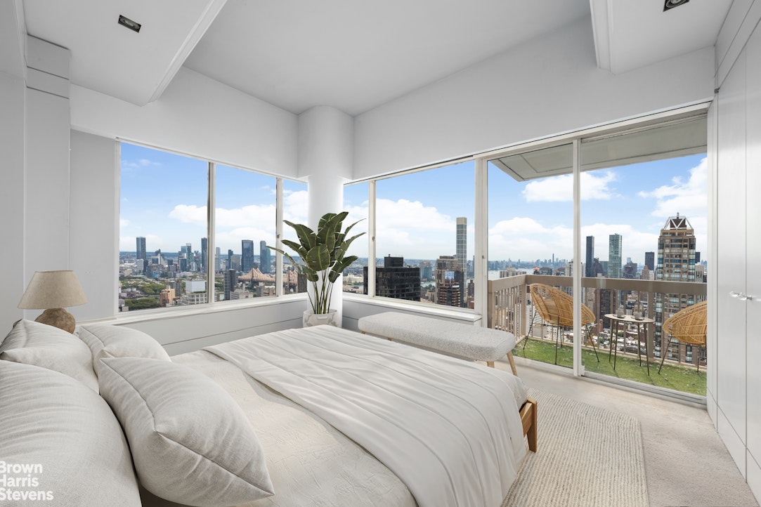 200 East 69th Street, Unit 47 Manhattan, NY 10021 - Photo 20 of 30 a spacious bedroom with a large window and a bed