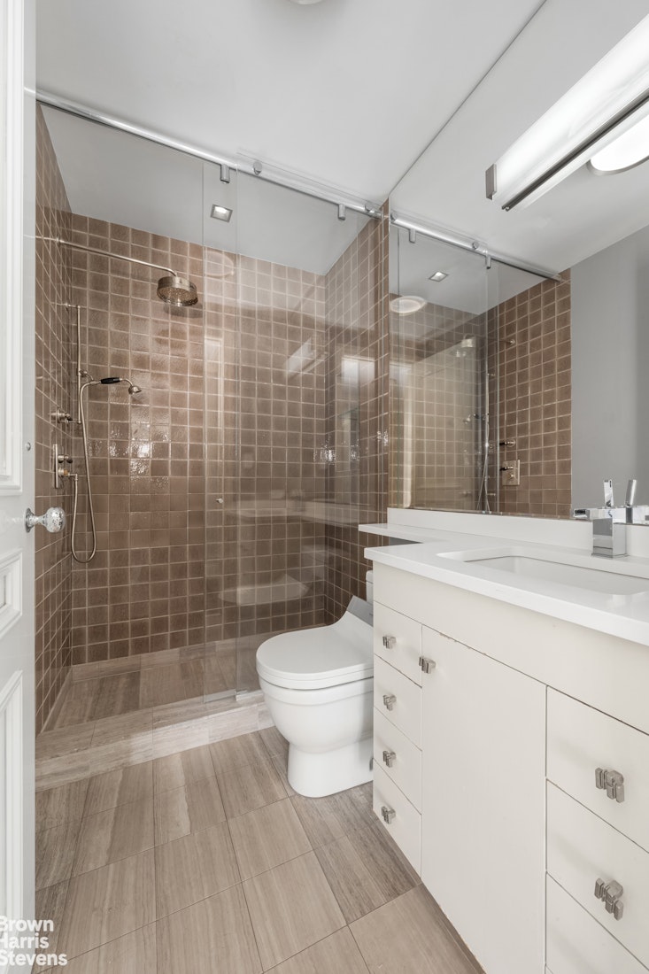 200 East 69th Street, Unit 47 Manhattan, NY 10021 - Photo 27 of 30 a bathroom with a sink a toilet and shower