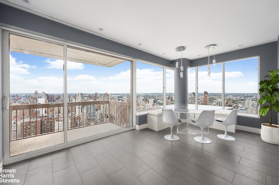 200 East 69th Street, Unit 47 Manhattan, NY 10021 - Photo 8 of 30 a very nice looking living room with a large window and a dining table with garden view