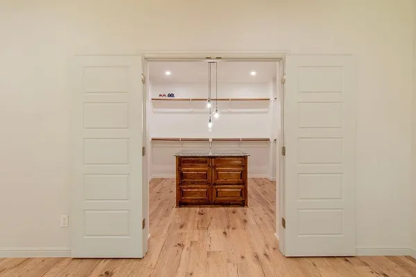 a kitchen with kitchen island granite countertop a refrigerator a sink dishwasher a stove and a dining table with wooden floor