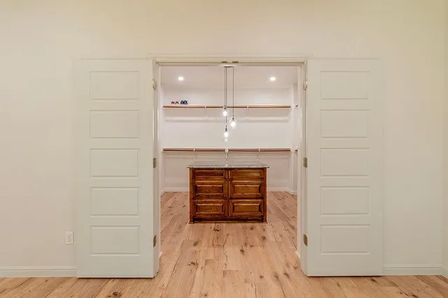 a kitchen with kitchen island granite countertop a refrigerator a sink dishwasher a stove and a dining table with wooden floor