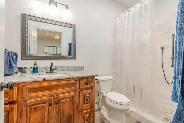 a view of a bedroom with furniture window and a ceiling fan