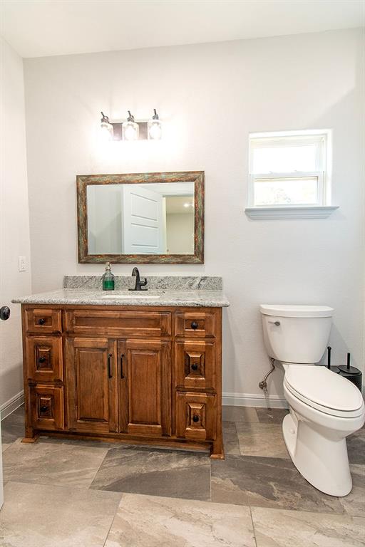 280 Lanier Road Combine, TX 75159 - Photo 31 of 36 a bathroom with a granite countertop sink a mirror and a toilet