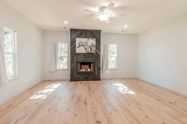 a view of an empty room with a window and fireplace