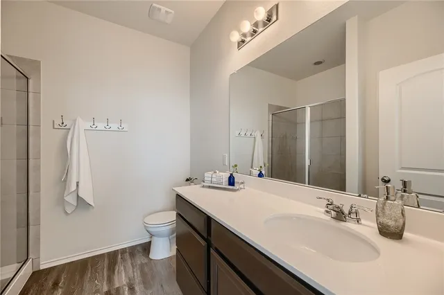 a bathroom with a double vanity sink toilet and a mirror
