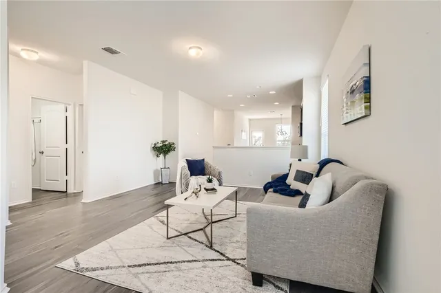 a living room with furniture and wooden floor