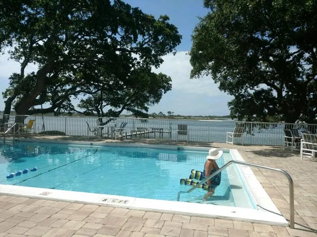 a view of a swimming pool with a patio and a lake view