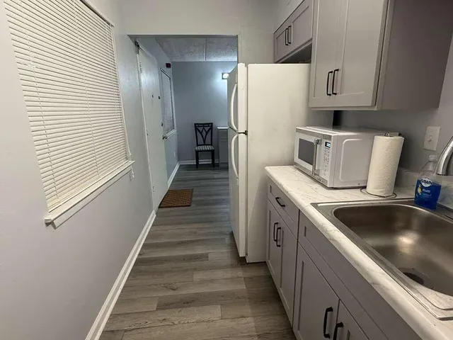 a kitchen with white cabinets and white appliances