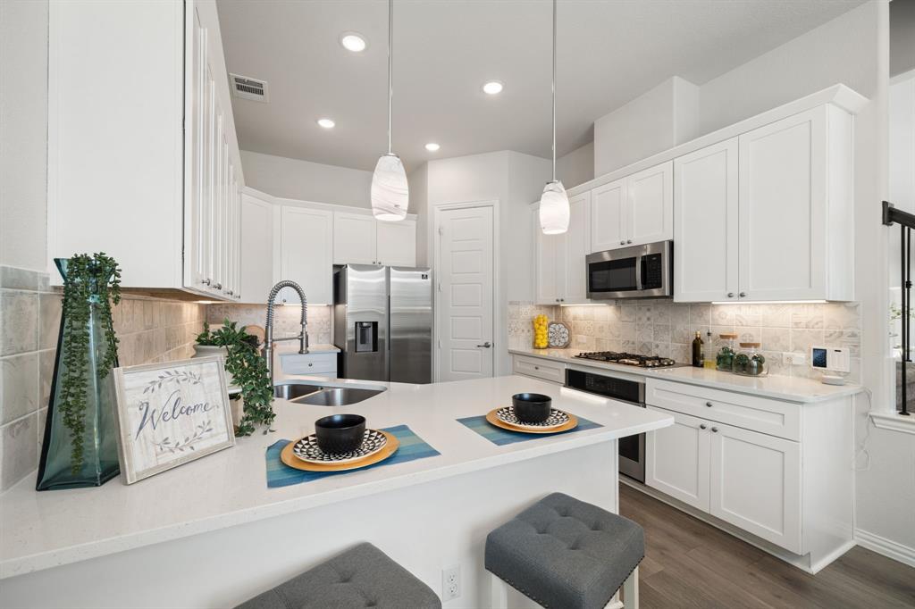 744 Patriot Lane Irving, TX 75060 - Photo 11 of 40 a kitchen with white cabinets and appliances