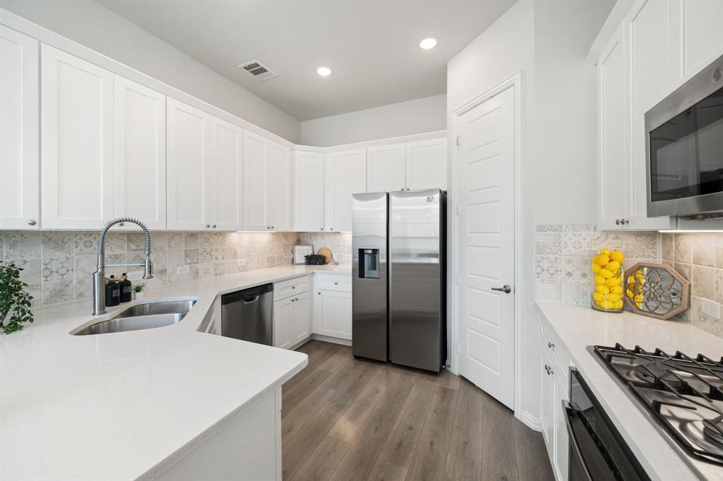 744 Patriot Lane Irving, TX 75060 - Photo 12 of 40 a kitchen with stainless steel appliances granite countertop a refrigerator a stove and a sink with wooden floor