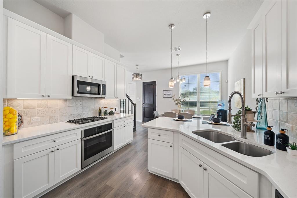 744 Patriot Lane Irving, TX 75060 - Photo 13 of 40 a kitchen with a sink white cabinets and stainless steel appliances