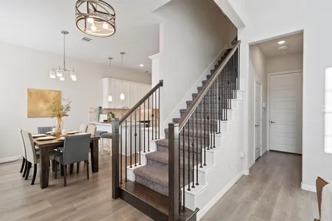 an entryway with a dining room and wooden floor