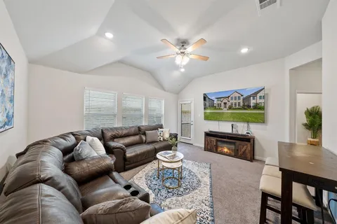 a living room with furniture a fireplace and a flat screen tv