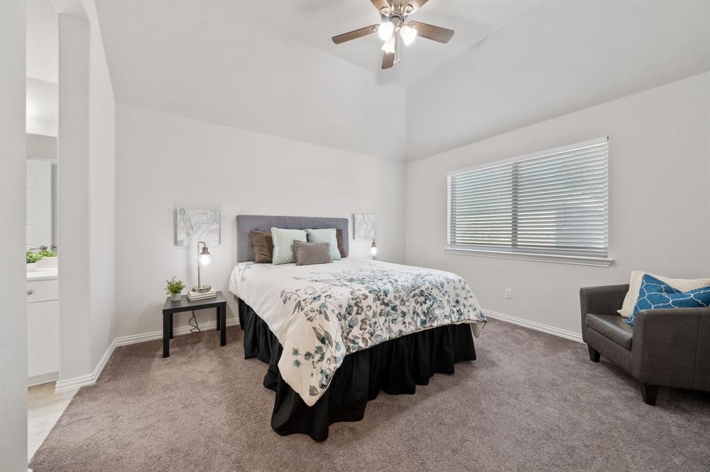 744 Patriot Lane Irving, TX 75060 - Photo 25 of 40 a spacious bedroom with a bed and a chandelier