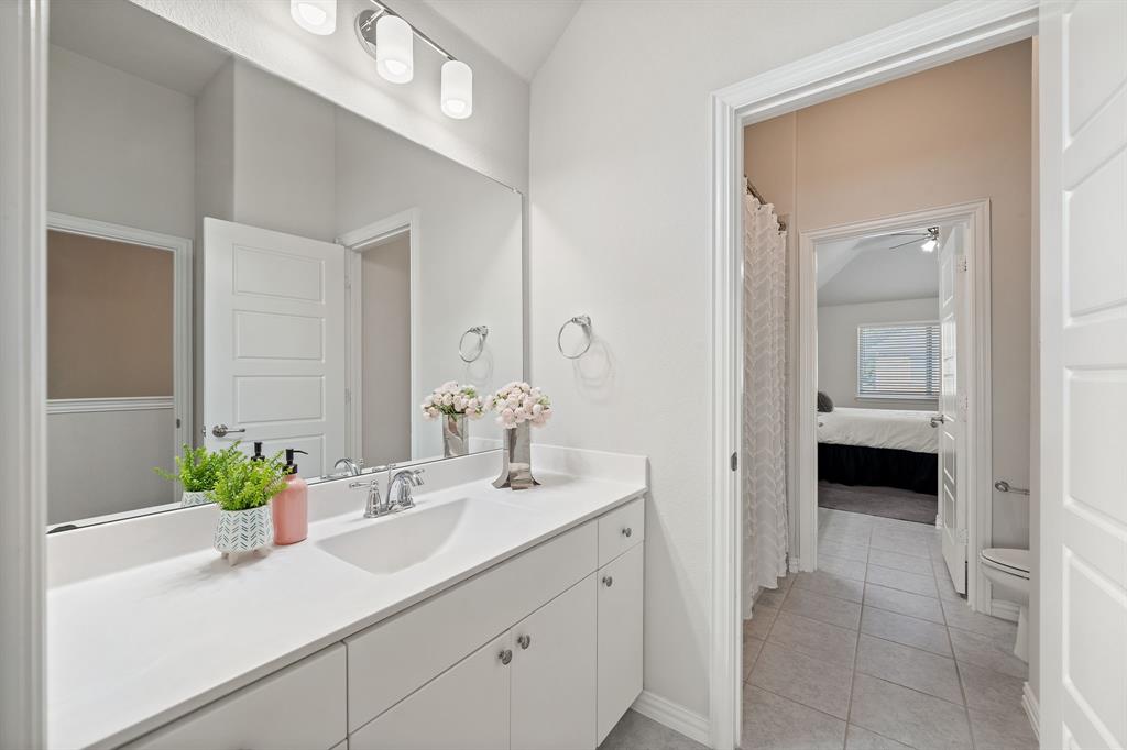 744 Patriot Lane Irving, TX 75060 - Photo 27 of 40 a en suite bathroom with a sink and a mirror