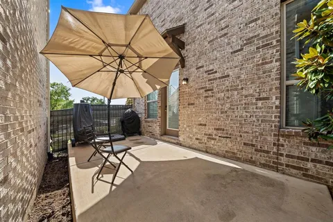 a view of a patio with a table and chairs under an umbrella