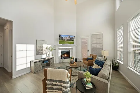 a living room with fireplace furniture and a large window