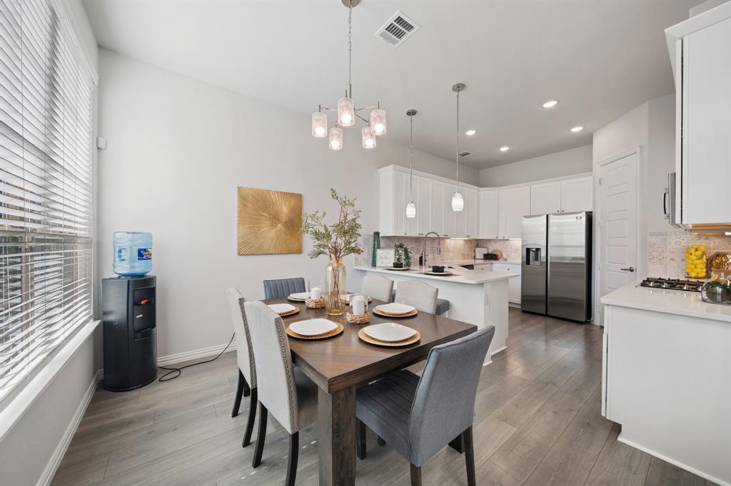 744 Patriot Lane Irving, TX 75060 - Photo 9 of 40 a view of a dining room and livingroom with furniture a chandelier and kitchen view