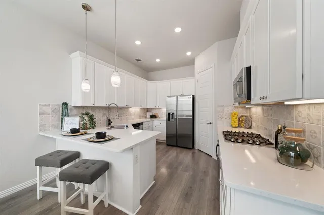 a kitchen with stainless steel appliances kitchen island granite countertop a sink and cabinets